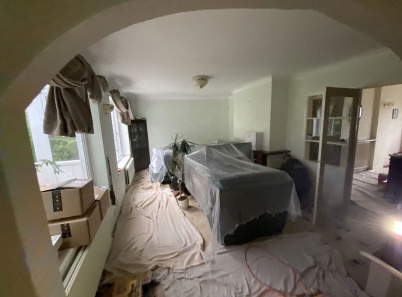 Sofa sheeted over and boxes stacked by the radiator, where we will not be working - preparing a home for a house rewire